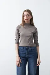 Polera de algodón color blanco, con cuello alto y mangas tres cuartos. Presenta un diseño ajustado al cuerpo con costuras decorativas en las sisas.