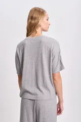 Remera de corte oversize confeccionada en tejido de lanilla acanalada, con cuello redondo y mangas cortas.