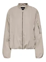 Campera bomber oversize color beige, con cuello estilo baseball, cierre frontal con cremallera, bolsillos laterales con botón a presión y un bolsillo con cierre en la manga izquierda. Tiene puños y dobladillo elásticos.