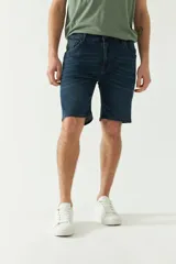 Bermuda de jean azul oscuro con bolsillos delanteros y traseros, cierre con cremallera y trabillas para cinturón.
