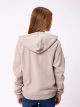 Canguro con cierre frontal de la marca Rusty, en color beige. Presenta capucha, bolsillos tipo canguro y logo bordado en el pecho.