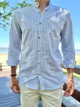 Camisa de manga larga con cuello mao, a rayas verticales en tonos gris y blanco, con botones frontales de madera.