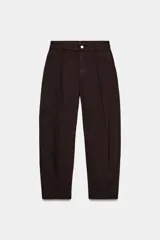 Pantalón de tiro alto con pinzas delanteras, corte balloon con pierna holgada que se estrecha hacia el tobillo. Cuenta con bolsillos frontales, bolsillos de plastrón en la parte trasera y cierre frontal con cremallera y botón.