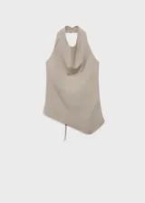 Top color beige, con cuello drapeado, diseño sin mangas, espalda abierta con cierre de lazo y dobladillo asimétrico.