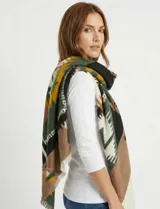 Pashmina cuadrada de gran tamaño con estampado geométrico en tonos tierra, verde, rosa y crema. Presenta bordes con acabado desflecado.