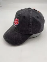 Gorro de béisbol negro con efecto lavado y estampa bordada de una flor de hibisco rosa.