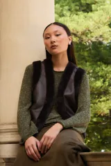 Chaleco reversible de corte recto, con un lado de cuero sintético color chocolate y el otro lado de piel sintética al tono. Presenta cuello redondo y diseño sin mangas.