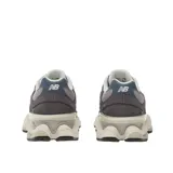 Championes New Balance modelo 9060, con diseño futurista inspirado en la estética de los años 2000. Presenta una combinación de tonos violeta, gris y crema, con entresuela esculpida que incorpora tecnología ABZORB para mayor amortiguación.