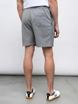 Bermuda de felpa negra con efecto lavado, corte recto y cordón ajustable en la cintura. Presenta un panel vertical en la parte delantera de cada pierna y el logo Umbro bordado en blanco en el muslo izquierdo.