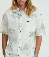 Camisa de hombre de corte relajado, color blanco con estampado de palmeras y paisajes playeros. Tiene cuello inglés, manga corta, abotonadura frontal y bolsillo en el pecho.