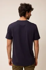 Remera básica de manga corta con cuello redondo y corte regular fit. Presenta un pequeño bordado en el pecho.