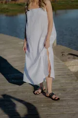 Sandalias negras de cuero con tira ancha sobre el empeine adornada con apliques circulares plateados.