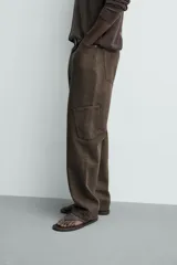 Pantalón cargo straight fit de algodón color negro con efecto lavado, bolsillos laterales en las piernas y cierre frontal con cremallera y botón.