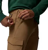 Pantalón cargo color marrón, confeccionado en tejido elástico resistente a la abrasión con tecnología Omni-Shield que repele la humedad y manchas. Presenta bolsillos laterales de carga con cierre a presión, bolsillos inclinados y trabillas para cinturón.