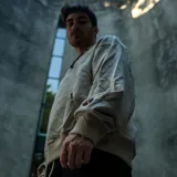 Canguro beige oversize de felpa liviana, con capucha y cordón ajustador color chocolate. Estampado frontal con raquetas de tenis cruzadas y texto "Septum Clvb Tenis House Montevideo Uruguay Limited Edition".