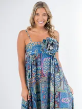 Vestido largo de algodón con estampado multicolor, corte cuadrado y elástico en la espalda. Incluye un aplique de flor desmontable.