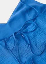 Vestido midi de tirantes finos y escote en V, color azul, con costuras decorativas verticales que realzan la silueta evasé.