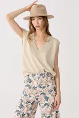 Chaleco tejido color dorado con lurex, escote en V y terminaciones de rib.