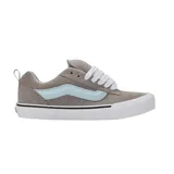 Championes Vans modelo Knu Skool, de diseño robusto y acolchado, color gris con la icónica banda lateral en celeste claro y cordones blancos. Presentan suela de goma blanca con detalle de línea negra.