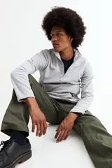 Buzo de polar gris con cuello alto y cierre frontal parcial, de manga larga y ajuste cómodo.