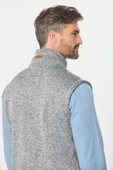Chaleco de felpa gris con textura jaspeada, cuello alto y detalle de etiqueta de cuero sintético en la nuca.