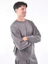 Buzo gris de corte holgado con cuello redondo y mangas largas.