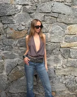 Top gris oscuro con escote halter profundo y diseño cruzado en el frente.