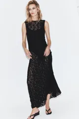 Vestido midi de encaje negro, con cuello redondo y diseño sin mangas.