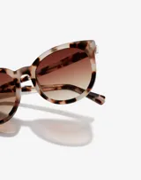 Lentes de sol Hawkers unisex, modelo Resort, con montura redonda de acetato color carey y lentes degradadas marrones.