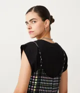 Enterito corto con tirantes finos y estampado a cuadros en tonos blanco, negro, verde y amarillo.