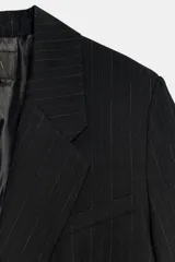 Blazer oversize de corte recto con estampado de raya diplomática, cuello con solapas de muesca, hombreras, manga larga y cierre frontal con botones. Cuenta con bolsillos de vivo en el delantero y forro interior.
