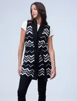 Chaleco largo tejido con cuello solapa, bolsillos delanteros, pasadores en la cintura y lazo para ajustar. Diseño con patrón de zigzag en blanco y negro.
