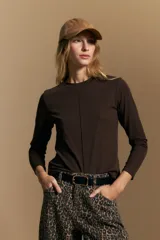 Remera de manga larga en color negro, con cuello redondo y costura vertical central en el frente. Presenta un diseño minimalista de calce ajustado y líneas limpias.