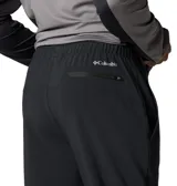 Pantalón Columbia Three Pitch Pant de color negro, diseñado para senderismo, con tecnología Omni-Shade UPF 50 y Omni-Shield que repele la humedad. Cuenta con cintura elástica con cordón interior, bolsillos para objetos pequeños, bolsillo de seguridad con cremallera, rodillas articuladas, cremalleras en las piernas y detalles reflectantes.