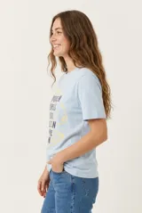 Remera de manga corta color beige, confeccionada en 100% algodón, con cuello redondo y estampa frontal con texto en tonos rosados.