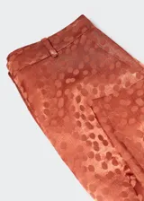 Pantalon de tiro alto con diseño recto, confeccionado en tejido satinado fluido con estampado de topos. Cuenta con trabillas en la cintura, dos bolsillos laterales y cierre oculto de botón, gancho y cremallera.