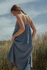 Vestido midi de denim color celeste, con escote recto, breteles finos y corte evasé amplio.