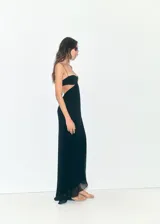 Vestido largo negro de la colaboración Supriya Lele x Mango, confeccionado en poliéster con forro de poliamida y elastano. Presenta diseño recto, tirantes finos, escote pronunciado, aberturas cut-out en los laterales y bajo asimétrico.