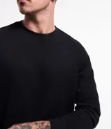 Buzo de cuello redondo y manga larga, confeccionado en tejido de media malla con puños ajustados. Diseño minimalista sin estampa.