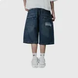 Bermuda de jean estilo baggy, color azul oscuro con efecto lavado. Presenta un corte holgado, bolsillos traseros amplios y un bordado decorativo con diseño de llamas y texto en uno de los bolsillos.