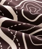 Remera de algodón peruano color marrón, con cuello redondo y mangas cortas. Presenta un diseño estampado en la espalda que ilustra un mapa topográfico con detalles de senderos y áreas naturales, acompañado de la frase Ishift Sight.
