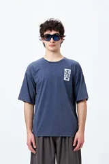 Remera azul con efecto gastado, corte holgado, mangas cortas y estampado de carta en el pecho.