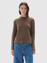 Polera de tejido de punto acanalado, con cuello subido y manga larga. Presenta un diseño al cuerpo con un pequeño bordado a tono en el frente.