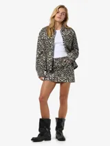 Pollera mini de tiro bajo confeccionada en sarga de algodón con estampado animal print de cebra y corte recto.