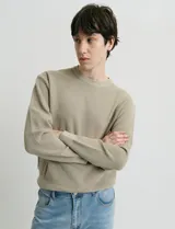 Sweater de punto con textura en color verde oscuro, de cuello redondo y manga larga.