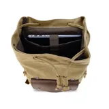 Mochila de tela canvas color negro con solapa y detalles en cuero sintético marrón. Presenta un cierre superior tipo marinero con cordón ajustable, solapa principal con correas y hebillas, y un bolsillo frontal con solapa. Posee bolsillos laterales con cierre metálico y correas de hombro ajustables.