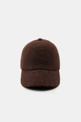 Gorra con visera confeccionada en tejido de punto con textura suave y acabado afelpado.