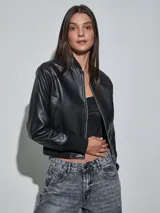 Campera bomber de eco cuero negro, con cierre frontal plateado, cuello, puños y cintura elastizados en rib.