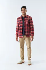 Sobrecamisa de viyela a cuadros rojos y negros con interior de corderito, cierre con botones, bolsillos tipo cartera y logo en goma.