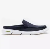 Zapato tipo mule de hombre con diseño de mocasín, confeccionado en cuero azul marino con costuras visibles. Presenta una suela blanca de goma con detalle en color verde neón en el talón.